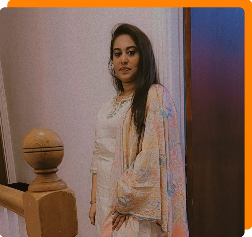 Myself standing by a wooden railing, wearing a light-colored traditional outfit with a pastel shawl.
